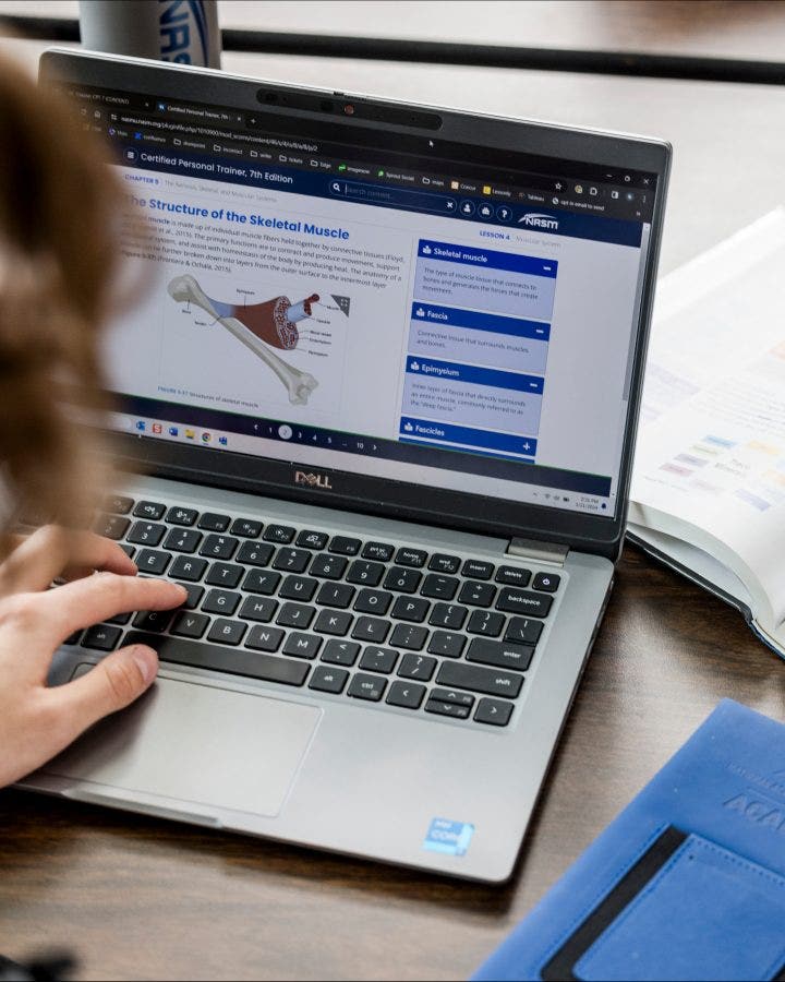 A woman instructs students at a desk