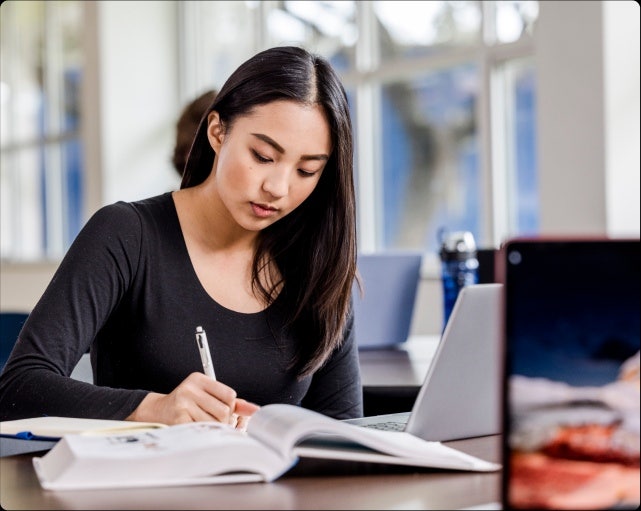 A woman studies at a laptop