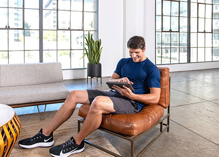 man viewing fitness specializations on his tablet