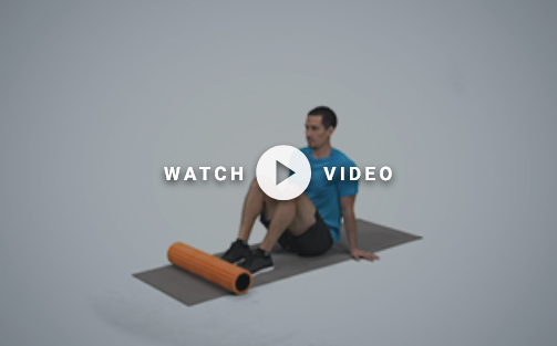 man sitting on the floor with foam roller at feet