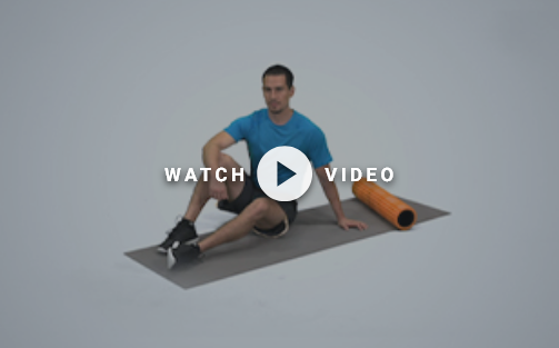 man sitting on the floor with foam roller