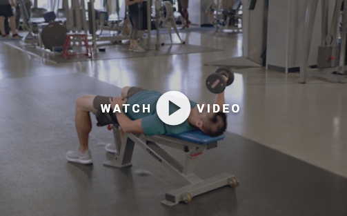 man using weight bench and dumbbell