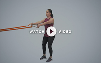 woman standing holding TRX band lateral