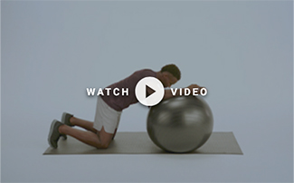 man forward leaning on medicine ball with arm on it
