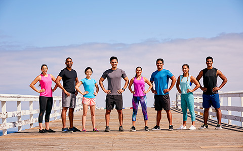 Eight people standing next to each other on a board walk