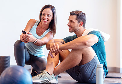 trainer and client sitting down while looking at phone