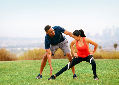 personal trainer helping a client stretch