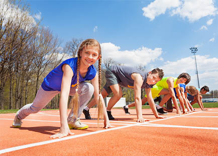 three youth running on a track