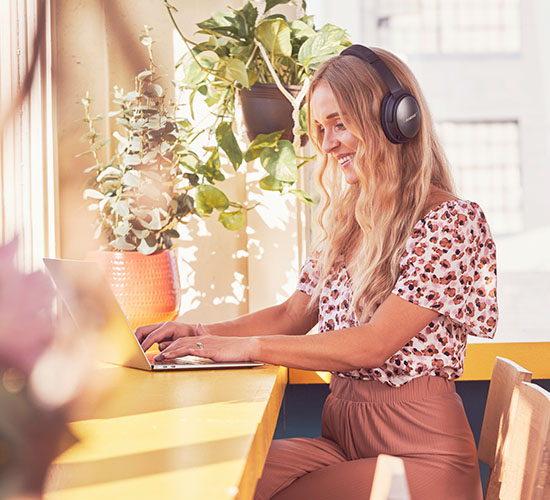 woman on a laptop with her headphones