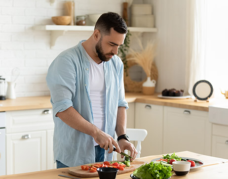 a man preparing vegetables in a kitchen after calculating calories