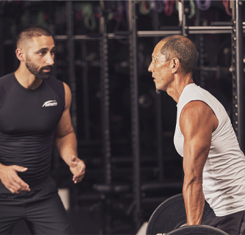 A male trainer helping a male client