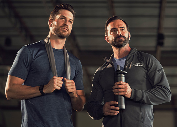 NASM trainer holding water bottle with client next to him