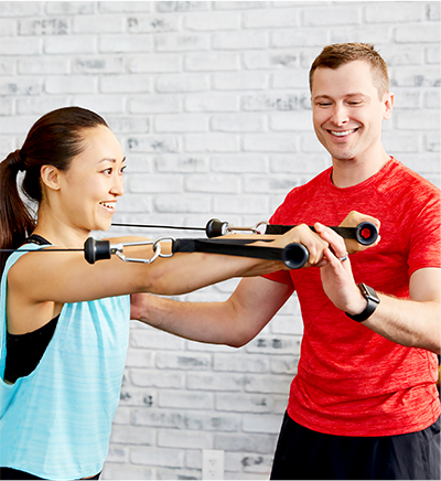 a trainer helping a client with a cable chest fly