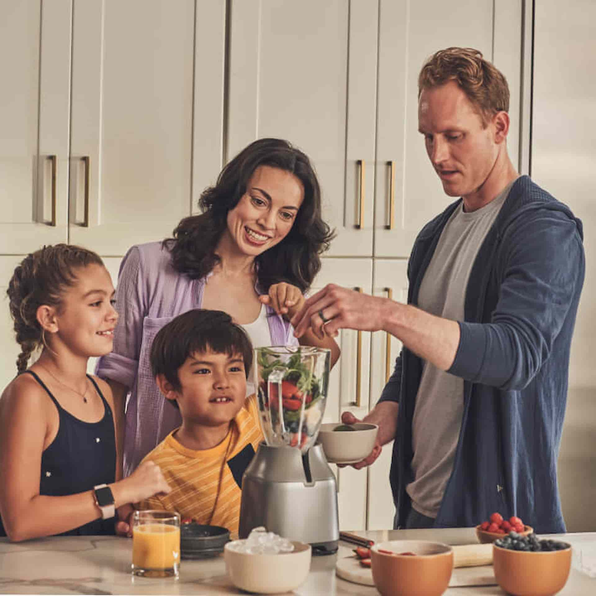 Young family making a healthy smoothie inside kitchen