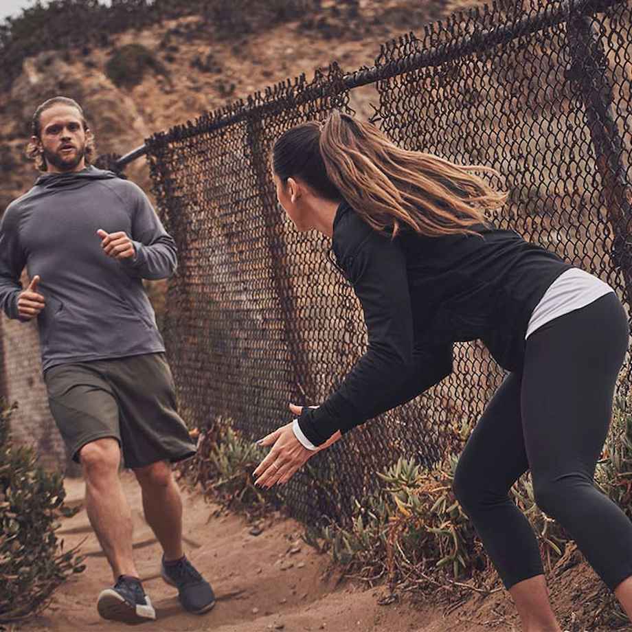 Female trainer motivating male athlete for outside run