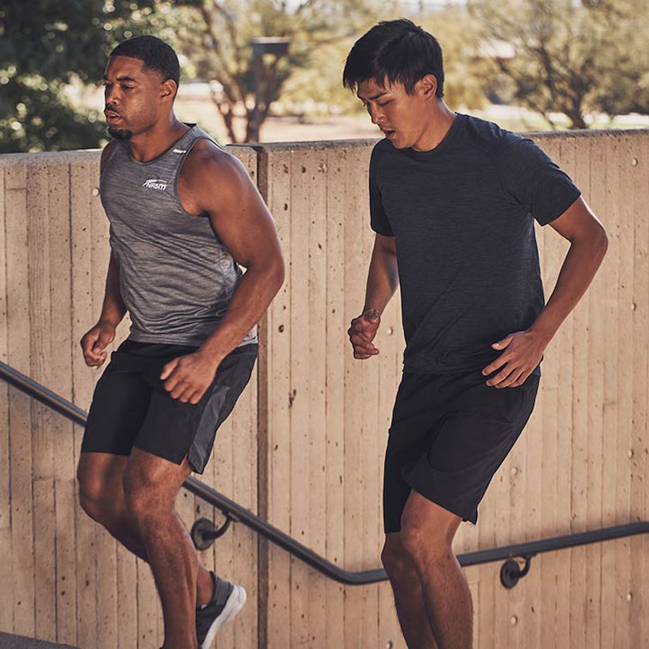 Male NASM trainer running outside with male client