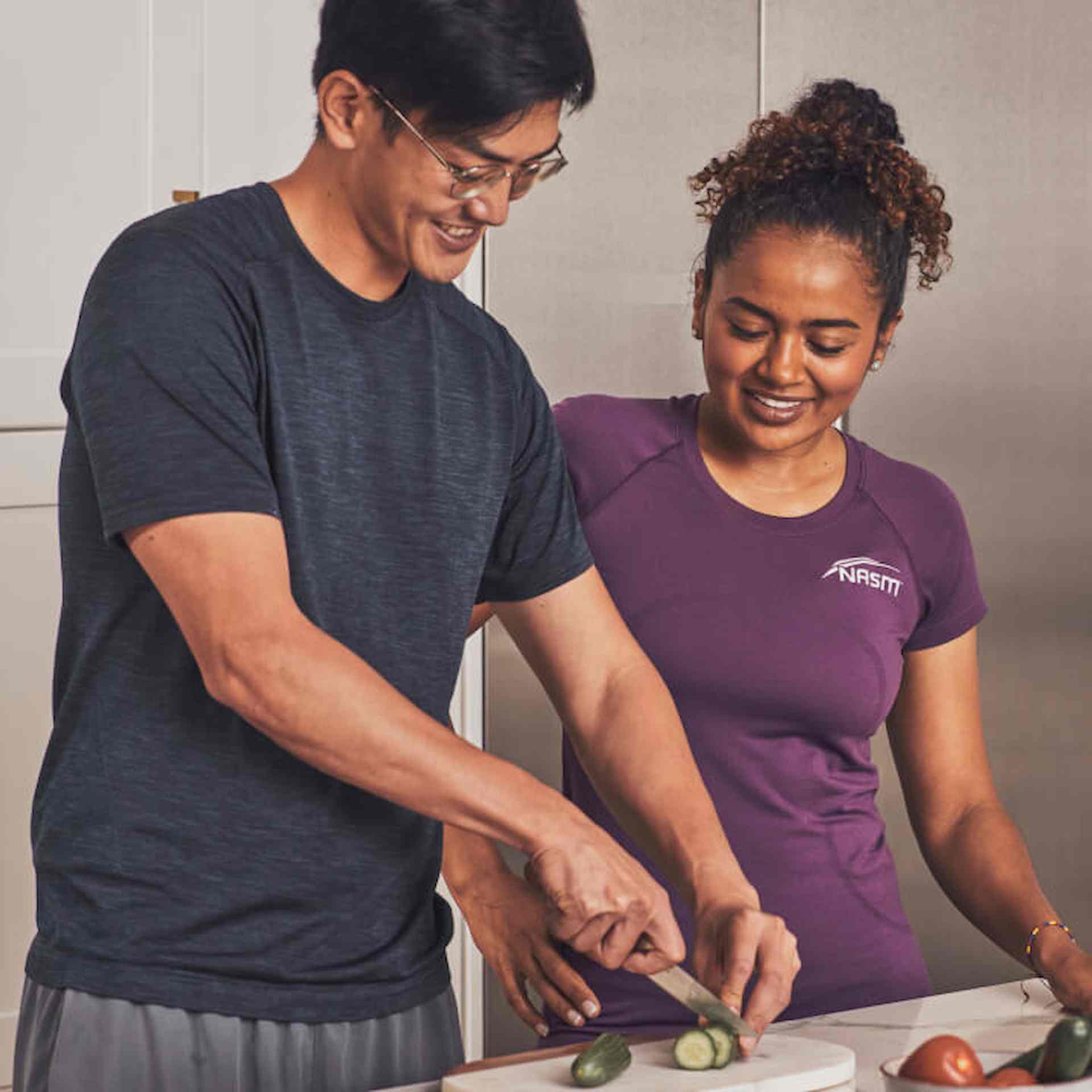 Female Nutrition Coach assisting client with cutting cucumbers