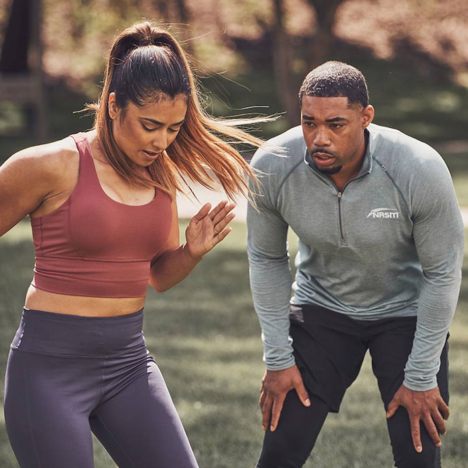 Male NASM trainer training female client outside