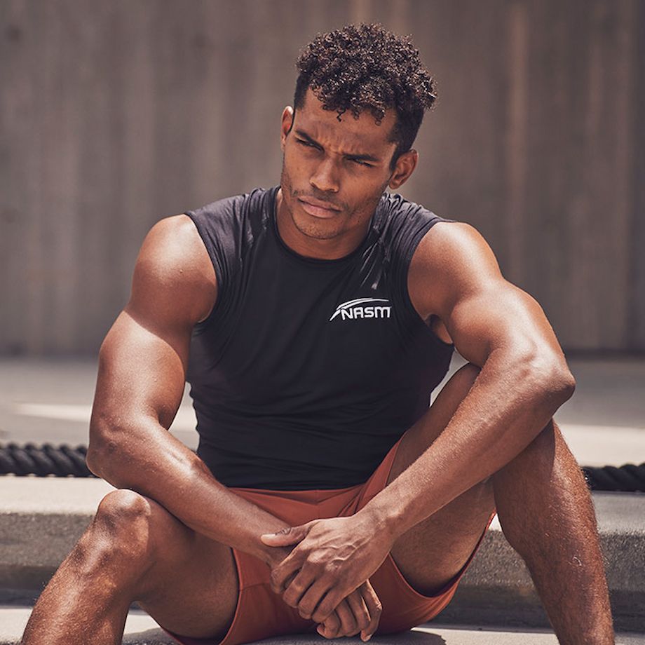 Male NASM trainer posing on cement steps