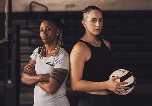 Female NASM trainer standing next to female client inside gymnasium
