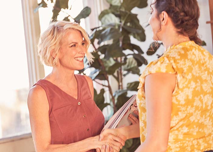 two women shaking hands