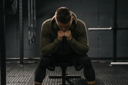 Male wearing Hoodie sitting on workout bench