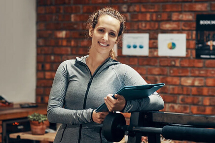 Female trainer wearing athletic jacket leading on workout stand