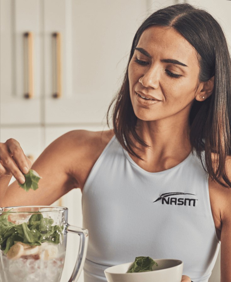 Female Nutrition coach making health smoothie inside kitchen