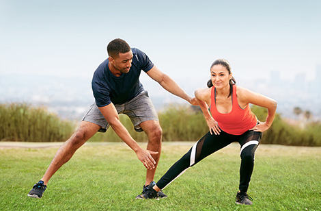 Trainer assisting client with a side squat