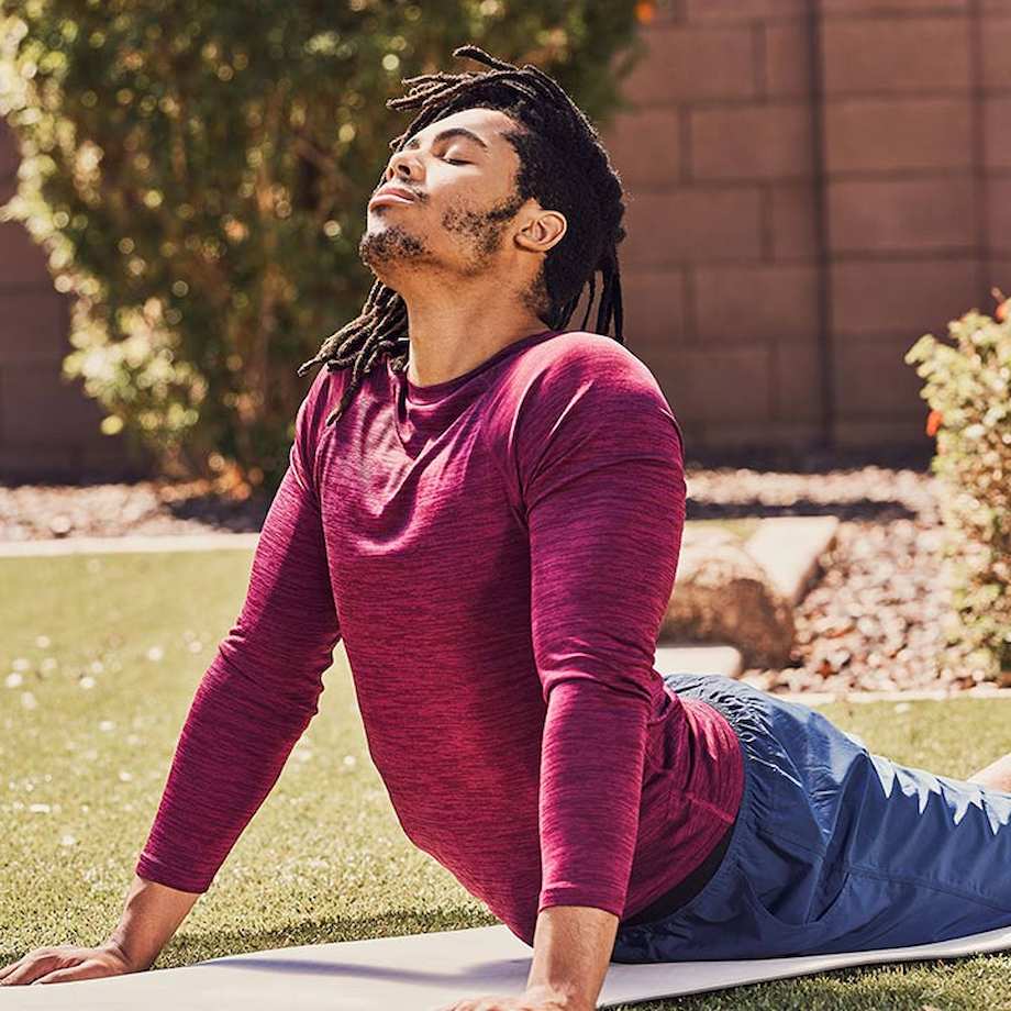 Male athlete doing cobra stretch outside