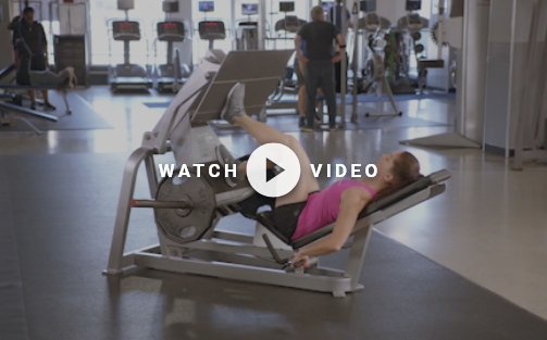 woman using a leg press machine