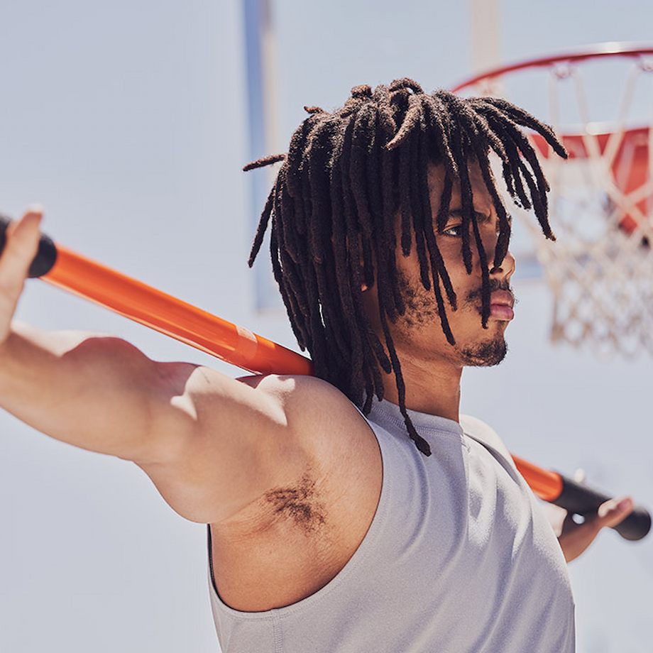 Male stretching arms with mobility stick outside