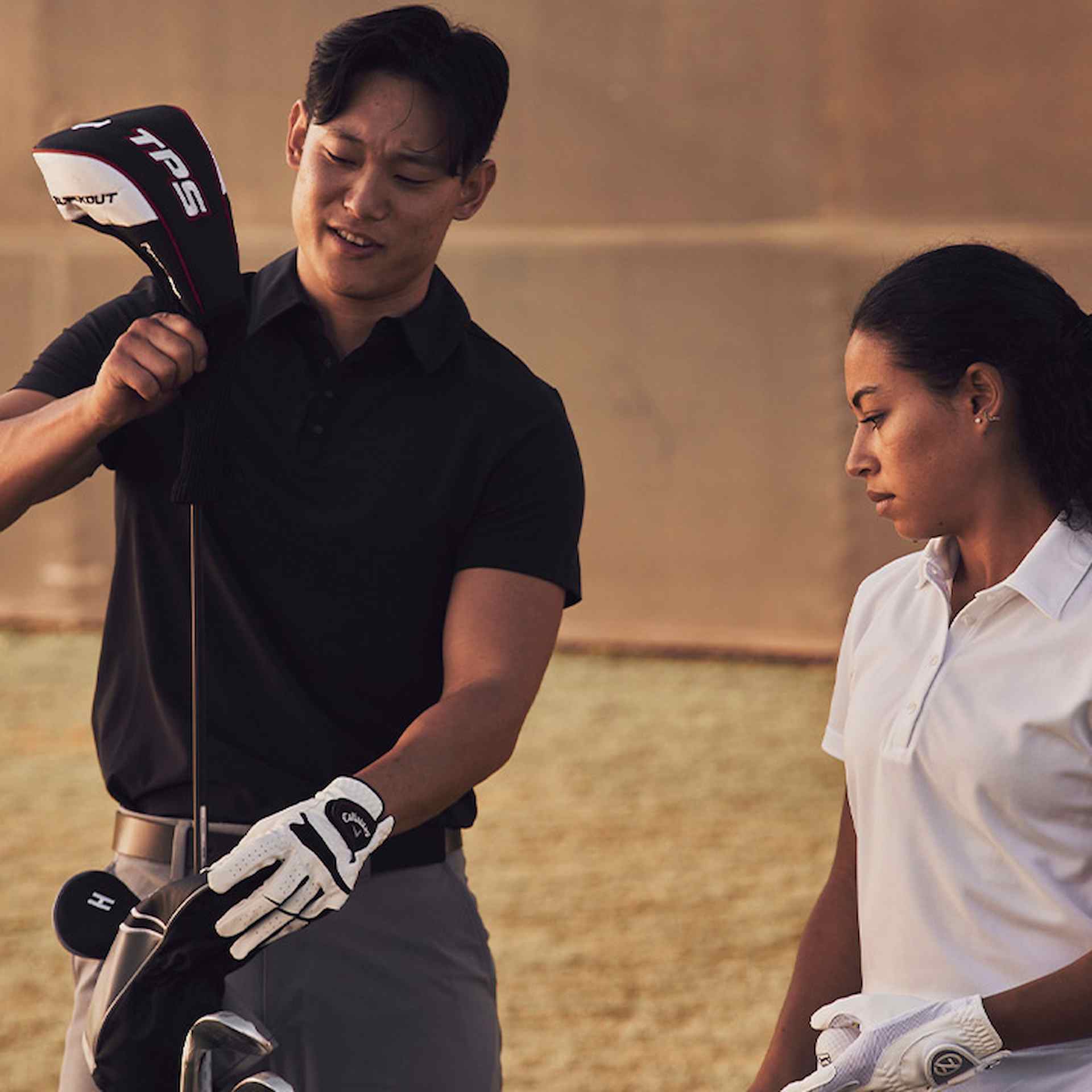 Female and Male athlete pulling out golf clubs outside
