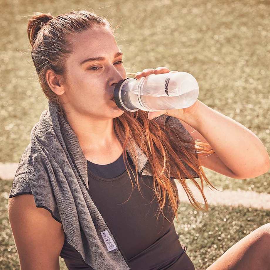 Female athlete drinking from water bottle
