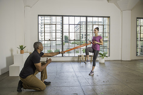 corrective exercise specialist training client with band