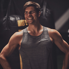 NASM trainer smiling away from camera inside gym