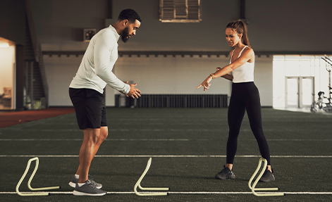 Trainer assisting client with workout