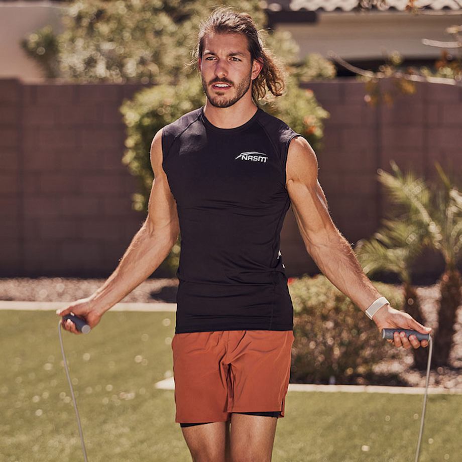 Male NASM trainer jump roping outside