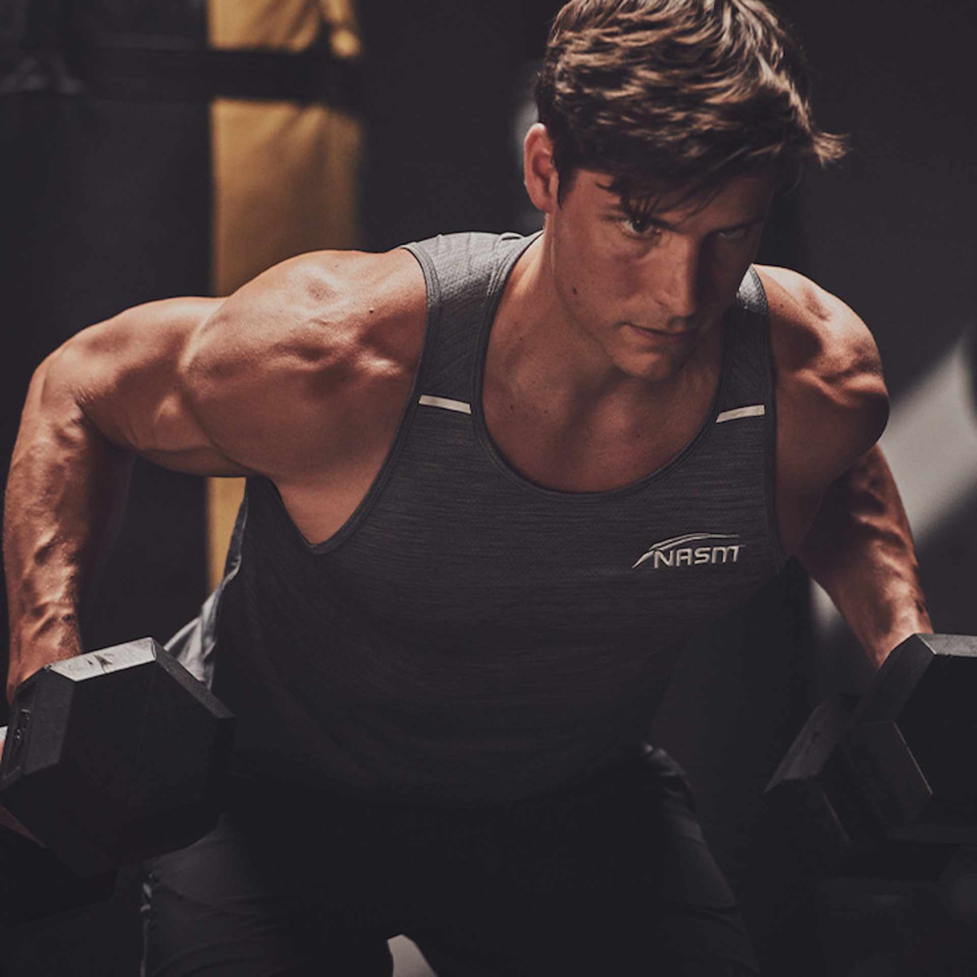 Male NASM trainer doing a dumbbell bent over row exercise