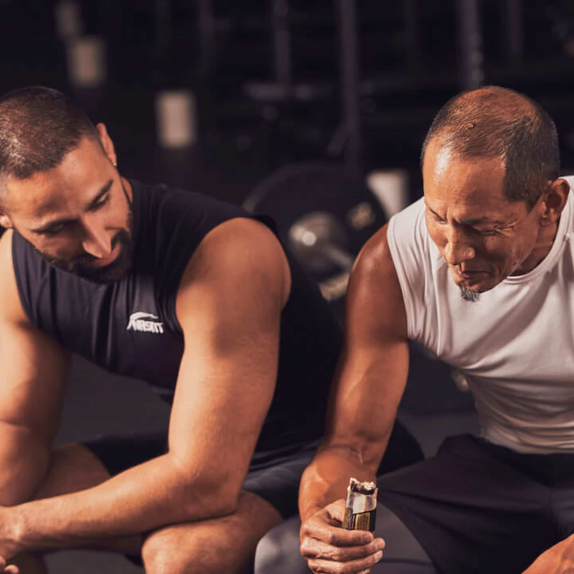 Male NASM trainer sitting and talking to male client