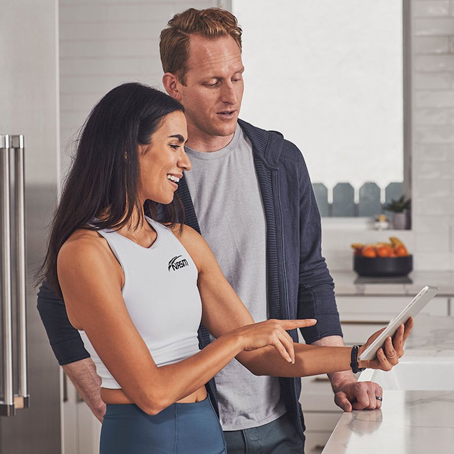 Female Nutrition coach showing male client something educational on tablet