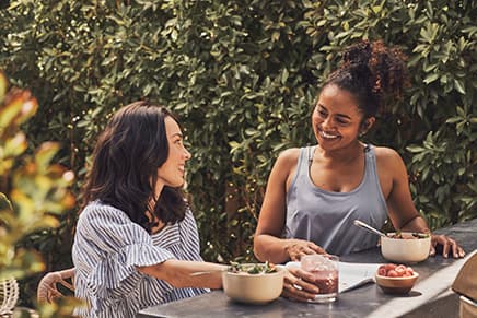 Two women enjoy a meal outside