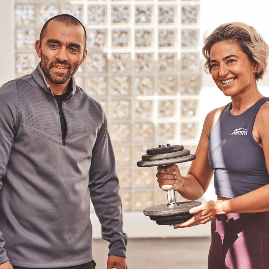 Male NASM trainer running down concrete steps with female client