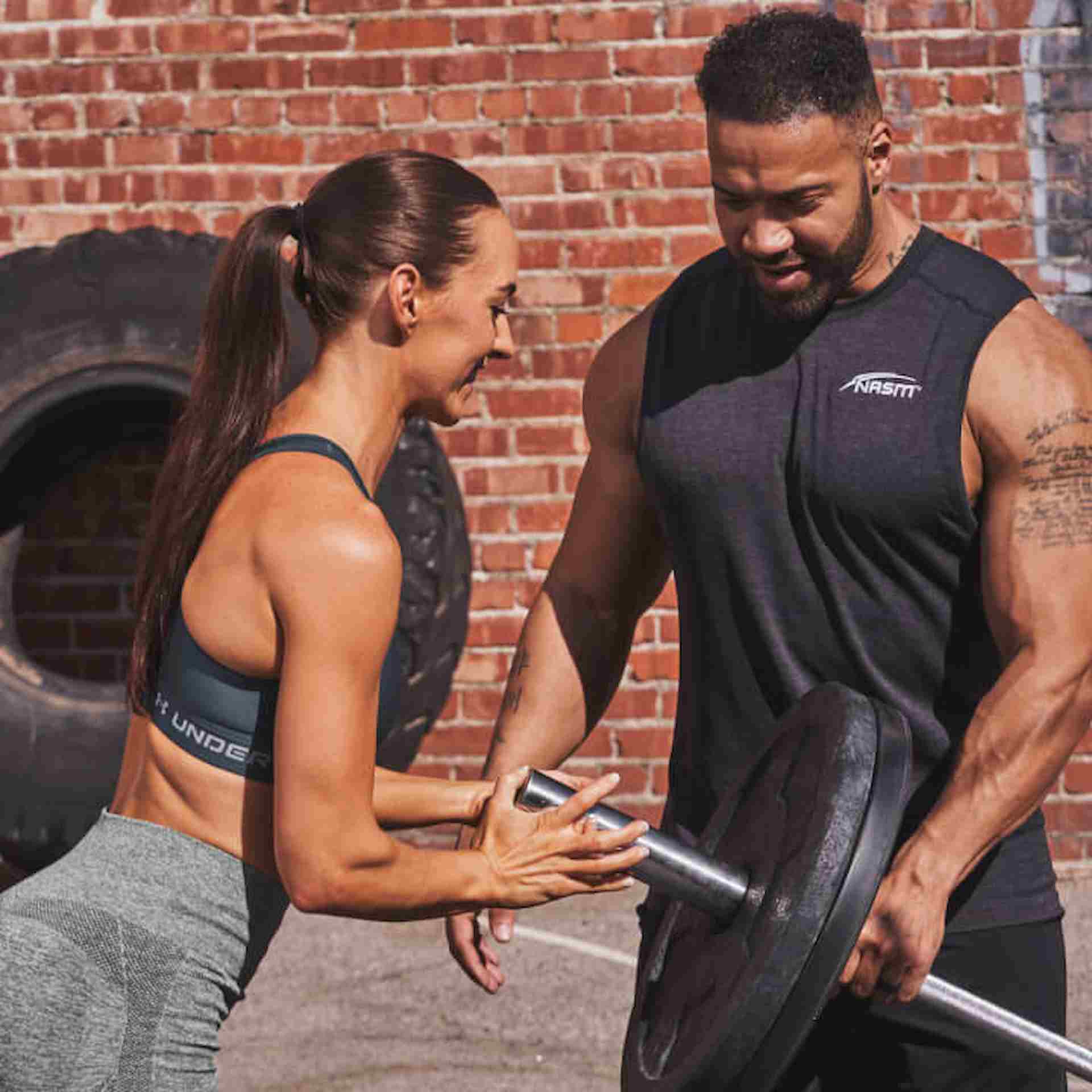 A male pbc coach helping a female client lift