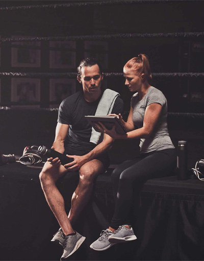 female trainer showing a male client a notebook