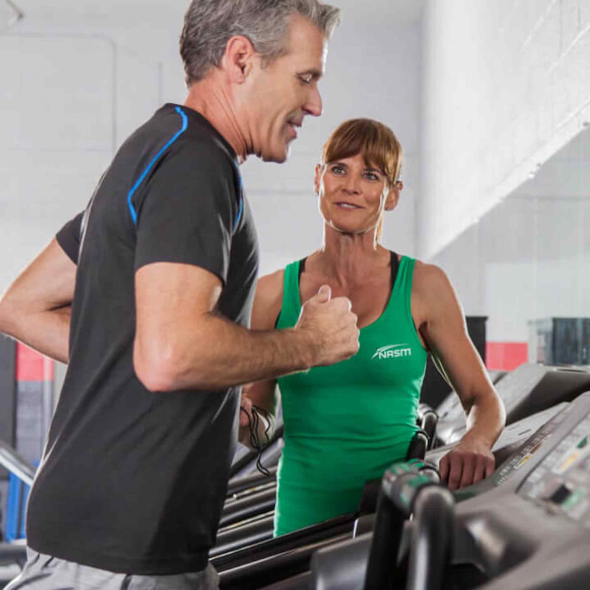 A man running on a treadmill next to a female SFS specialist