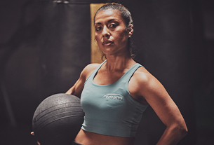 Female NASM trainer holding weighted ball