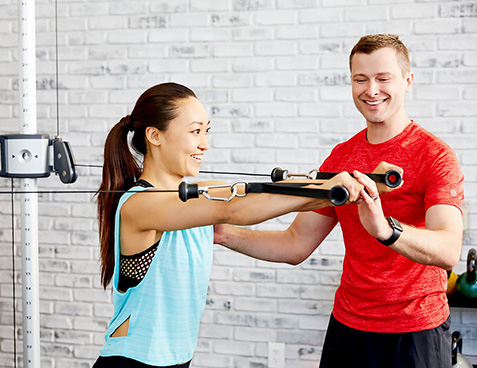 personal trainer training a client with strength endurance cable exercises