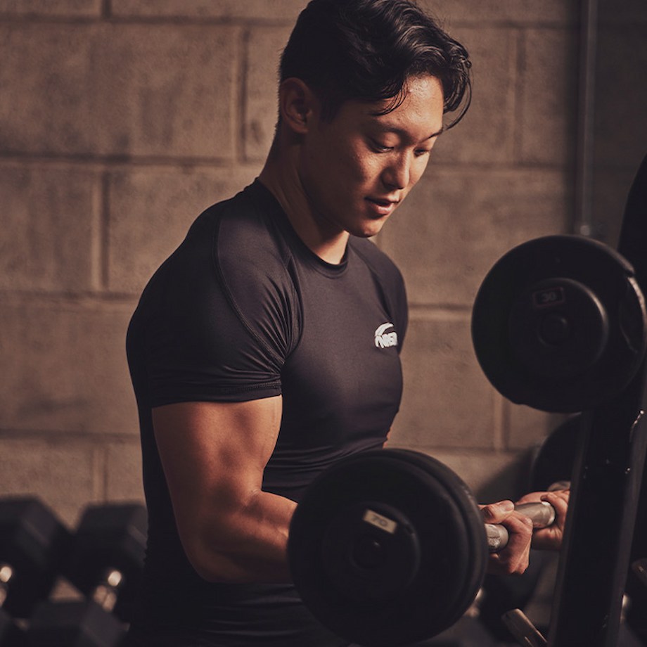 Male NASM trainer doing barbell bicep curl