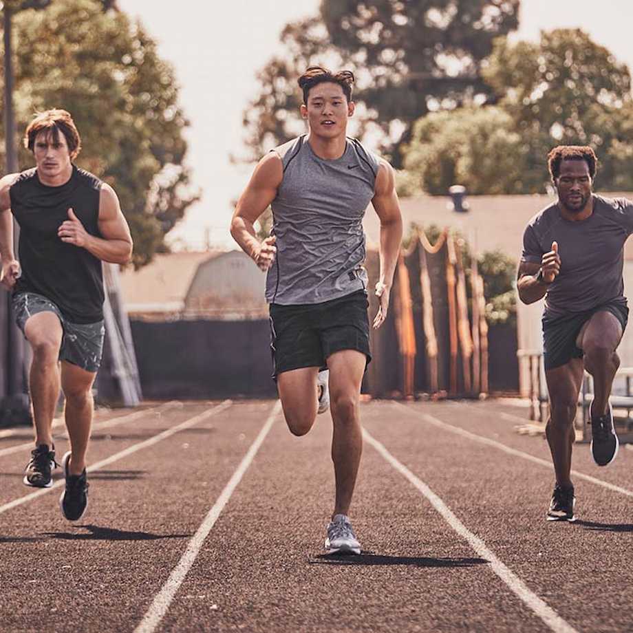 Group of male athletes running on outdoor track